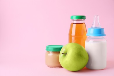 Photo of Healthy baby food, juice, apple and milk on pink background, space for text