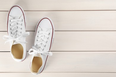 Photo of Pair of stylish sneakers on white wooden table, flat lay. Space for text