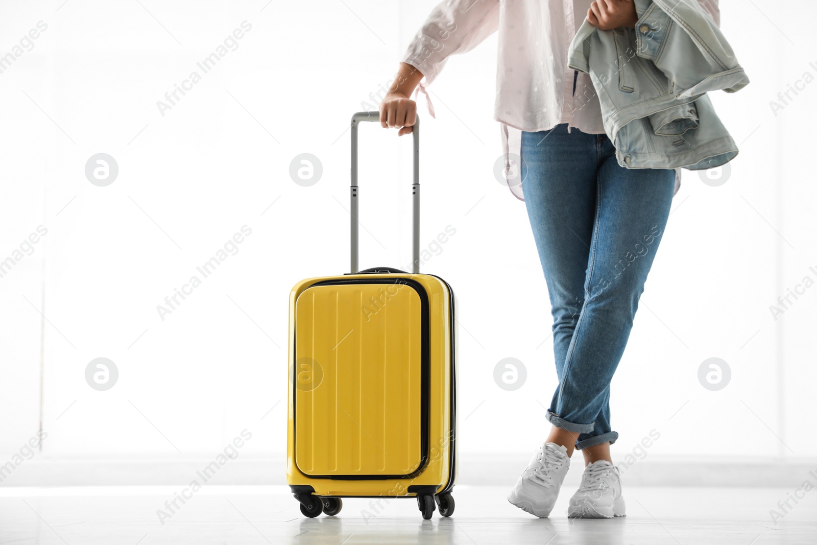 Photo of Woman with yellow travel suitcase in airport