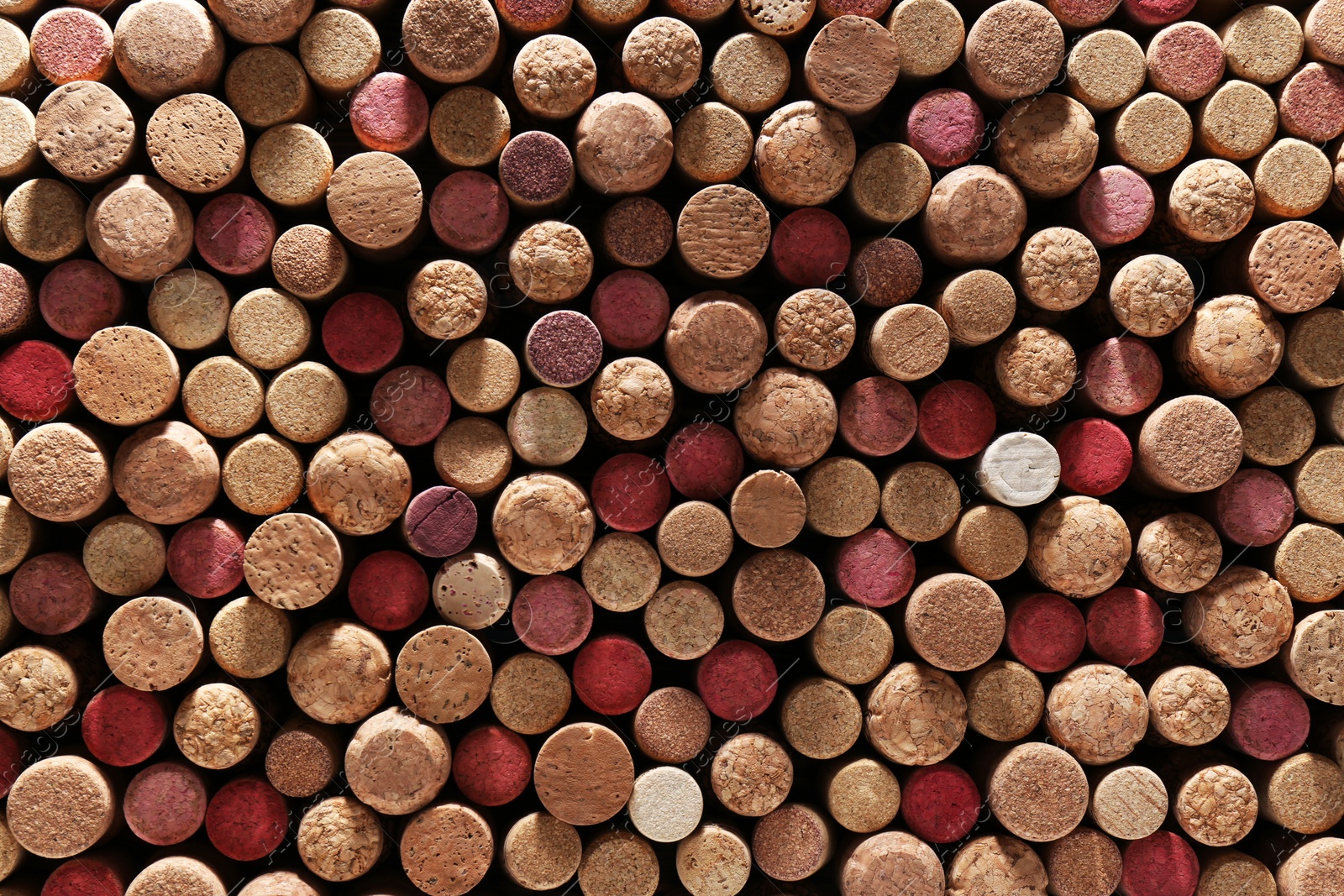 Photo of Many corks of wine bottles as background, top view