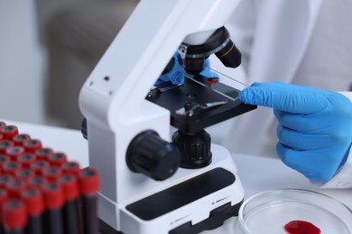 Scientist working with microscope in laboratory, closeup