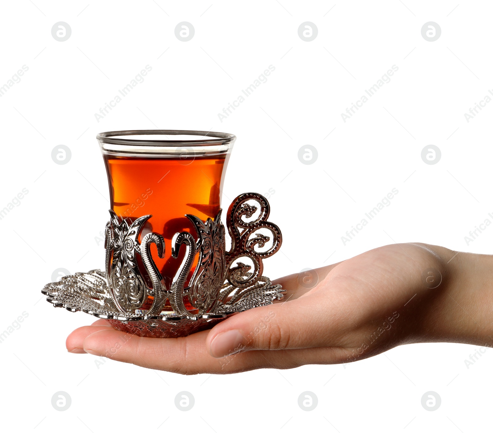 Photo of Woman holding glass of traditional Turkish tea in vintage holder on white background, closeup