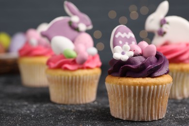 Photo of Tasty decorated Easter cupcakes on grey table, closeup