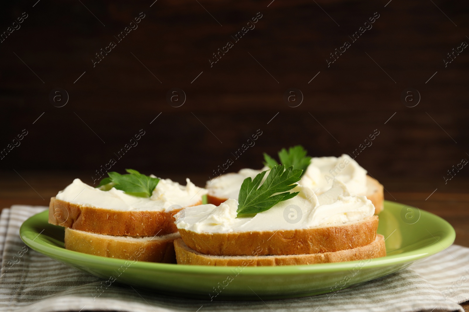 Photo of Bread with cream cheese and parsley on plate