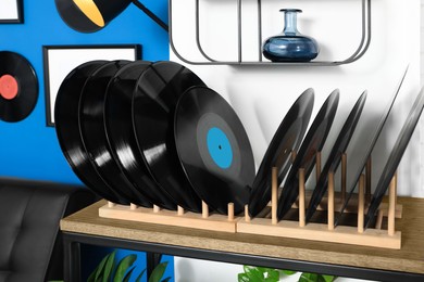 Vinyl records on wooden stand in living room