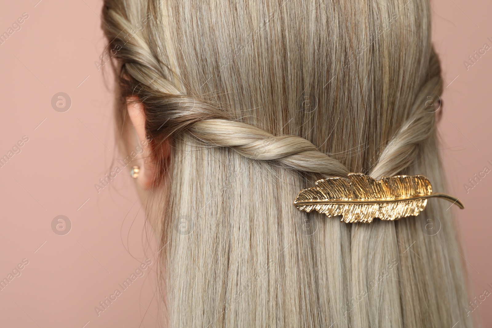 Photo of Young woman with beautiful gold hair clip on pink background, closeup