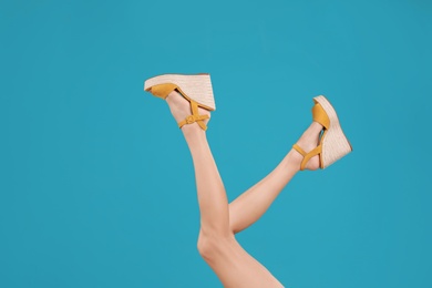 Photo of Woman in stylish shoes on light blue background