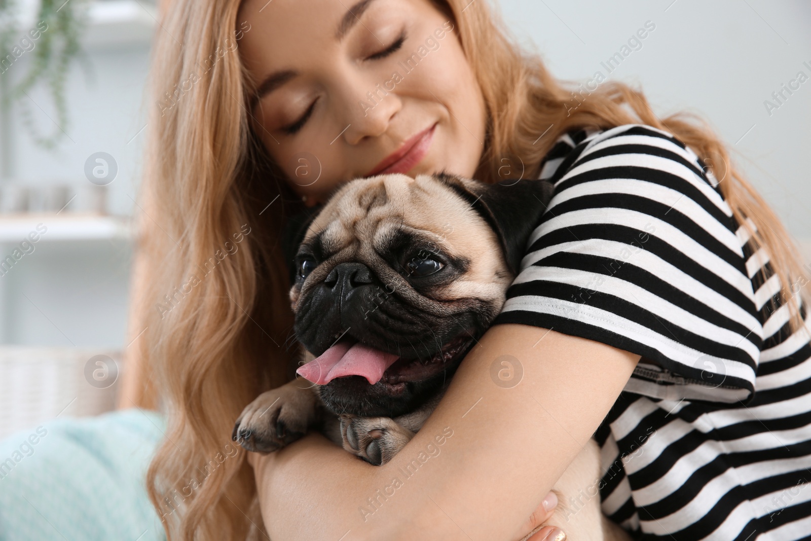Photo of Woman with cute pug dog at home. Animal adoption