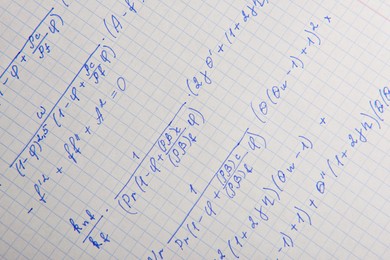 Paper with written mathematical calculations as background, closeup