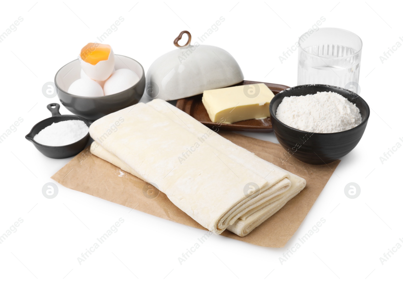 Photo of Raw puff pastry dough and ingredients isolated on white