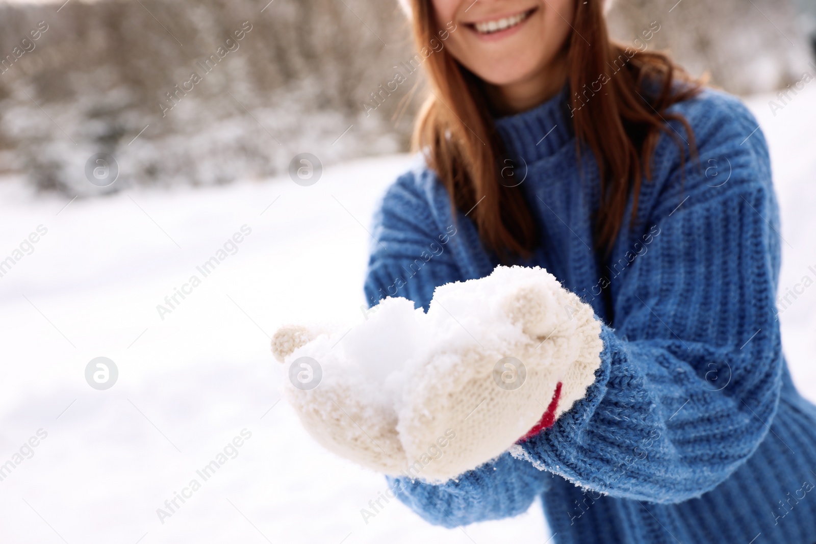 Photo of Young woman playing with snow outdoors, closeup. Winter vacation