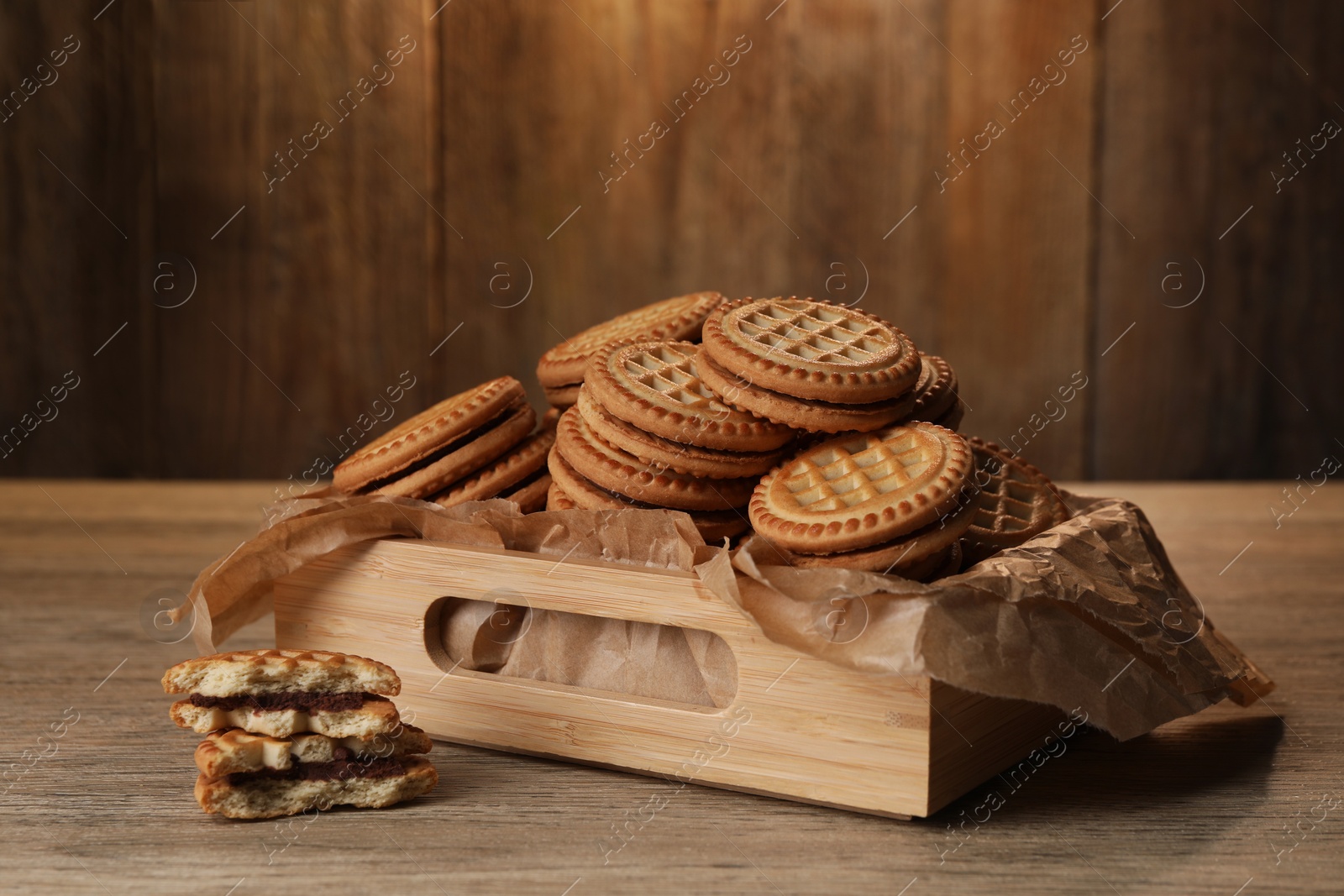 Photo of Tasty sandwich cookies with cream on wooden table