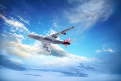 Image of Airplane flying in blue sky with clouds. Air transportation
