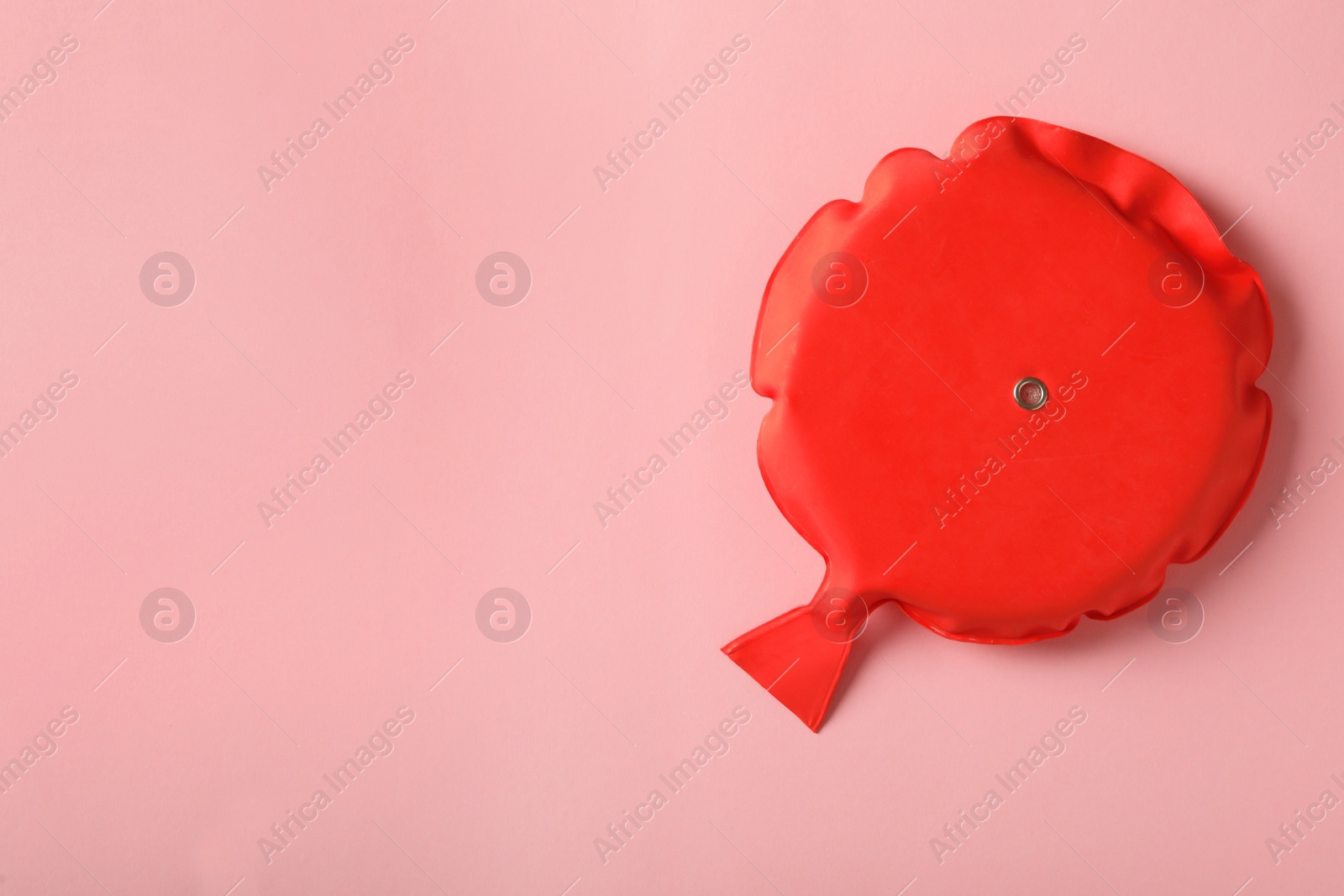 Photo of Whoopee cushion on pink background, top view. Space for text