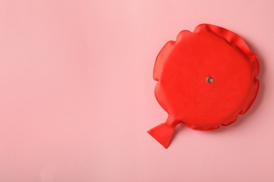 Photo of Whoopee cushion on pink background, top view. Space for text