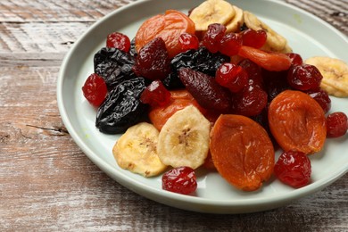 Photo of Mix of delicious dried fruits on wooden table, closeup