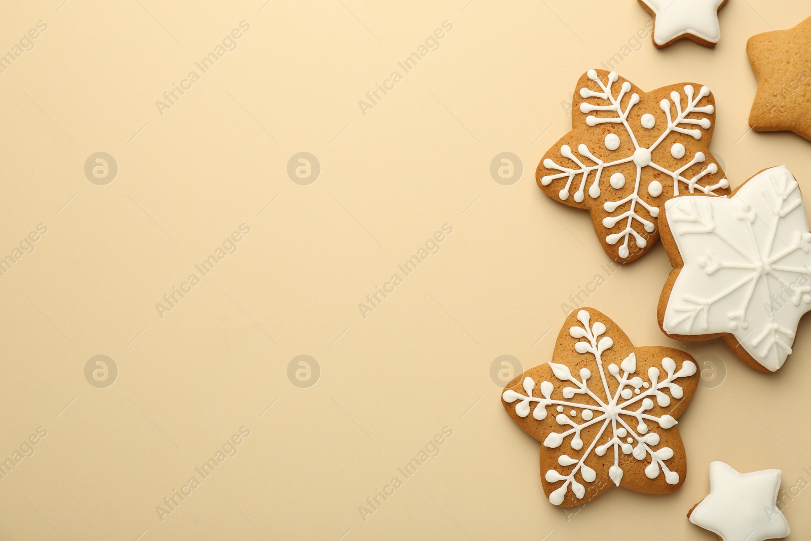 Photo of Tasty Christmas cookies with icing on beige background, flat lay. Space for text