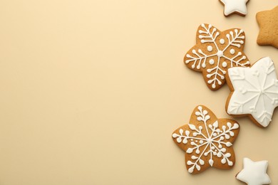 Photo of Tasty Christmas cookies with icing on beige background, flat lay. Space for text