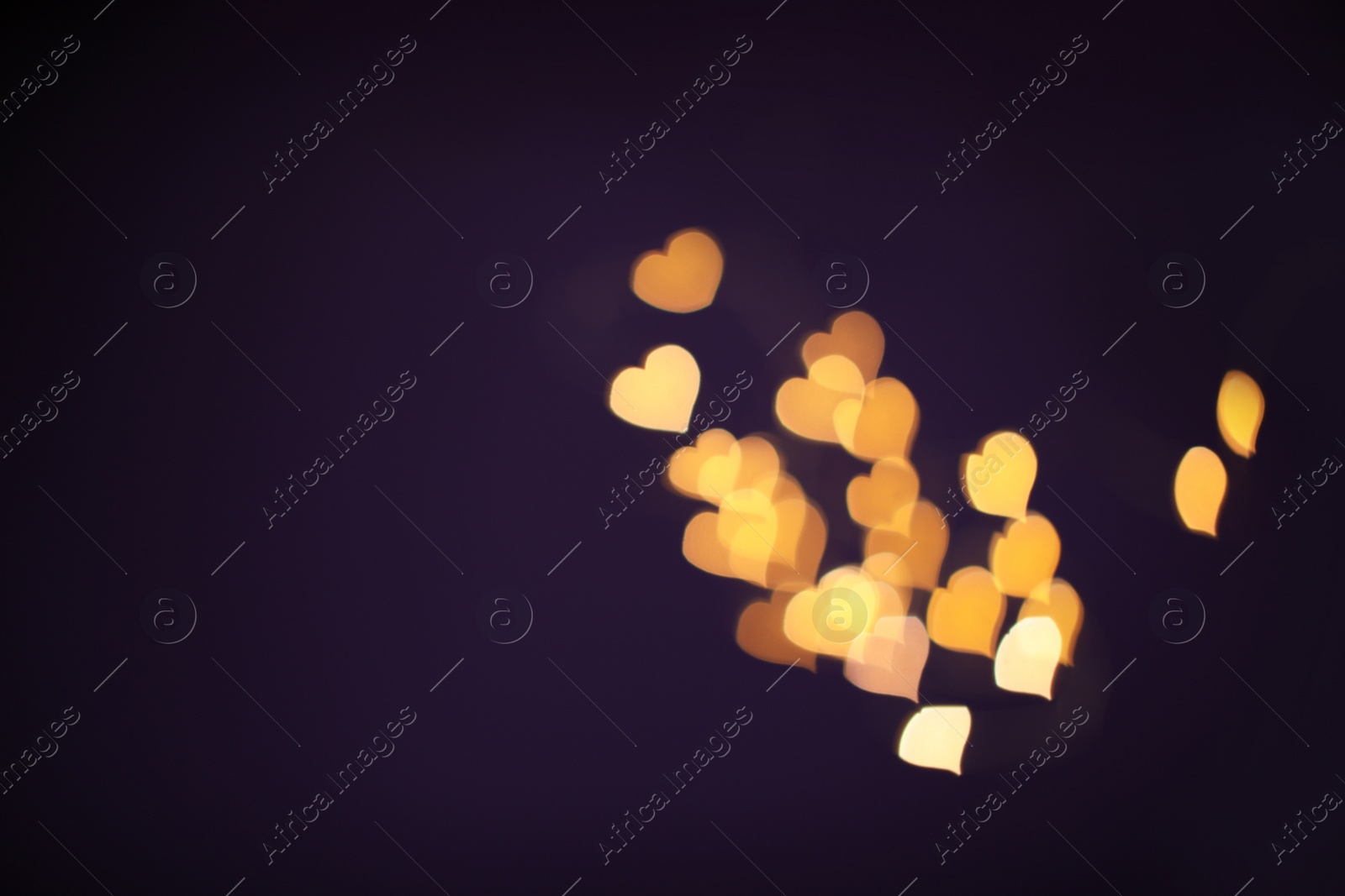 Photo of Blurred view of beautiful lights on purple background. Bokeh effect