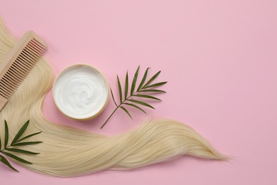 Lock of healthy blond hair, comb and cosmetic product on pink background, flat lay. Space for text