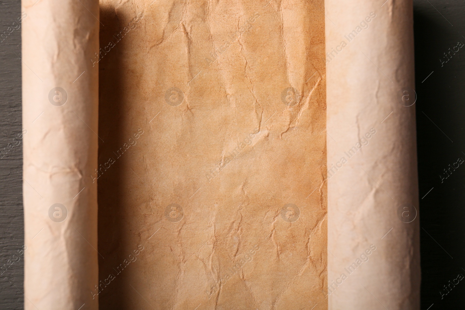Photo of Sheet of old parchment paper on grey wooden table, top view