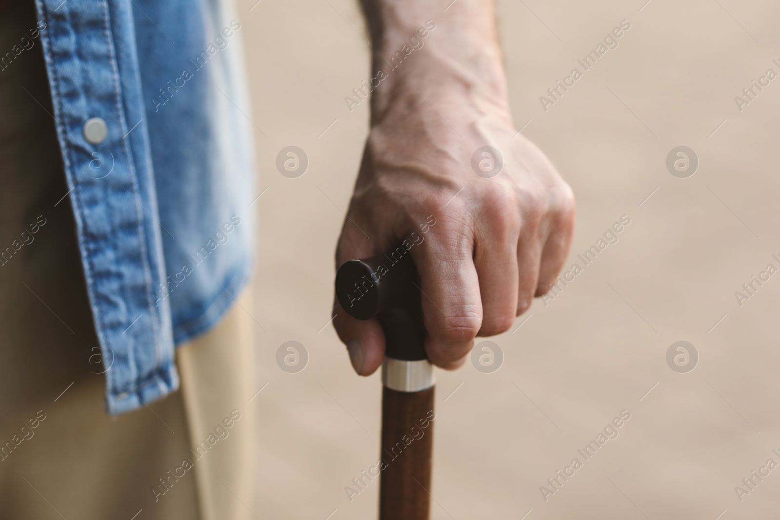 Photo of Senior man with walking cane outdoors, closeup