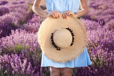 Photo of Young woman with hat in lavender field on summer day, closeup