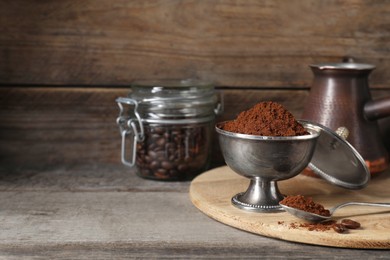 Ground coffee on wooden table, space for text