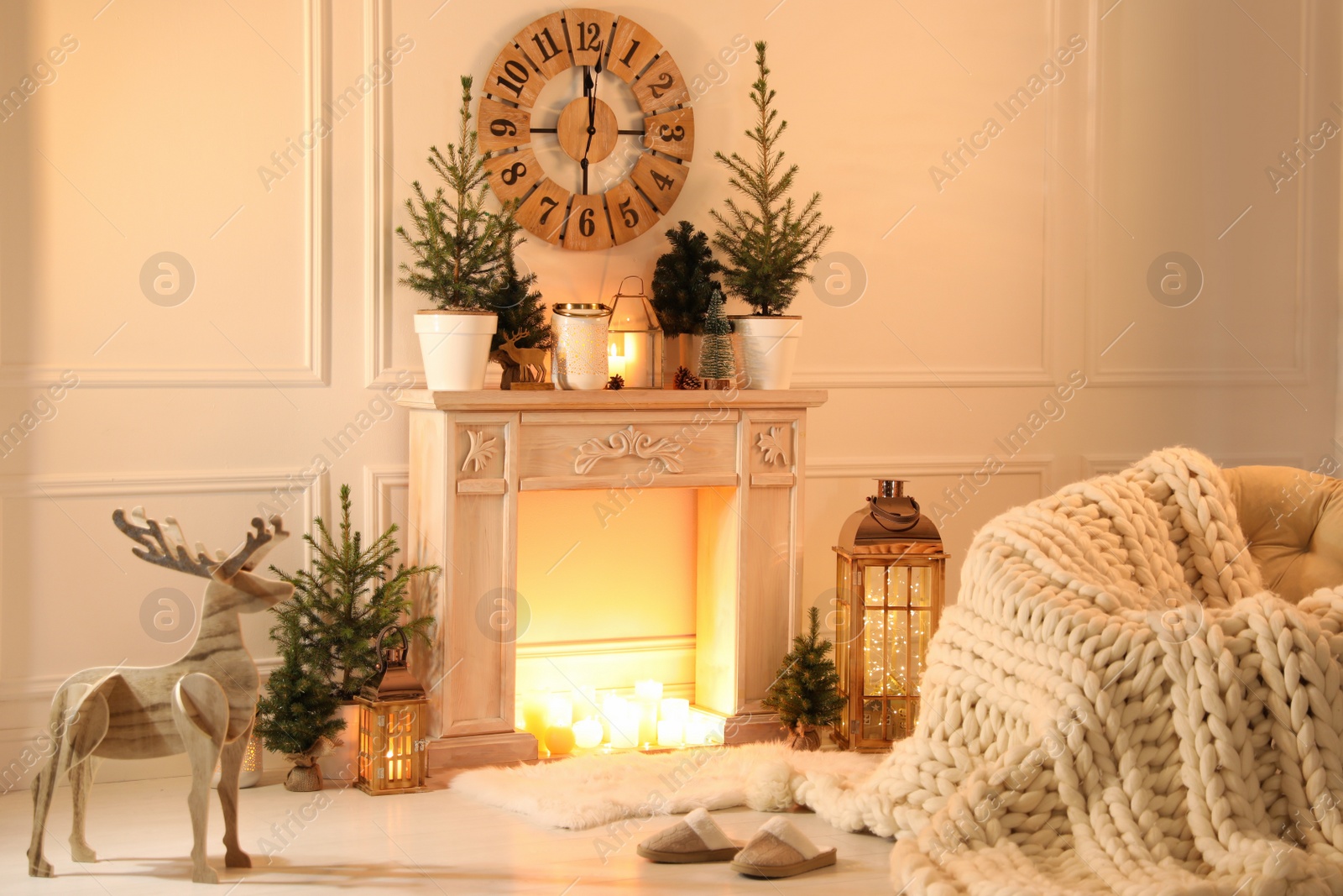 Photo of Beautiful room interior with decorative fireplace and potted fir trees. Christmas decor