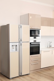 Interior of spacious modern kitchen with refrigerator