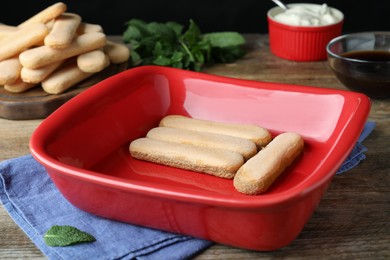 Bowl with tasty savoiardi biscuit cookies for tiramisu on wooden table