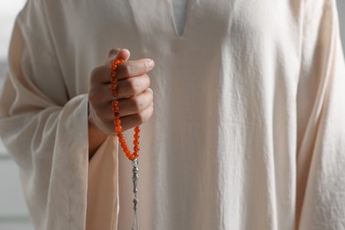 Photo of Muslim man with misbaha beads, closeup view