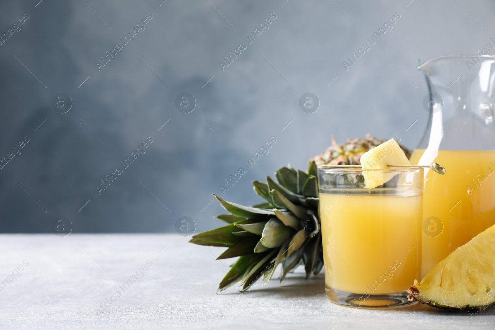 Photo of Freshly made pineapple juice on light table. Space for text