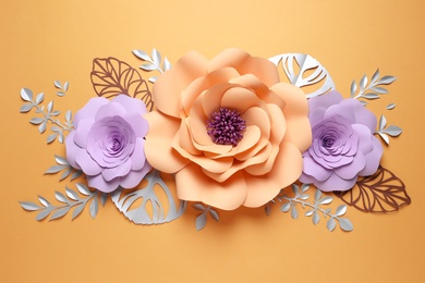 Photo of Different beautiful flowers and branches made of paper on orange background, flat lay