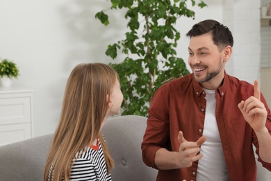 Photo of Father talking with his teenager daughter at home