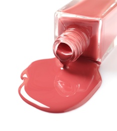 Photo of Spilled color nail polish with bottle on white background