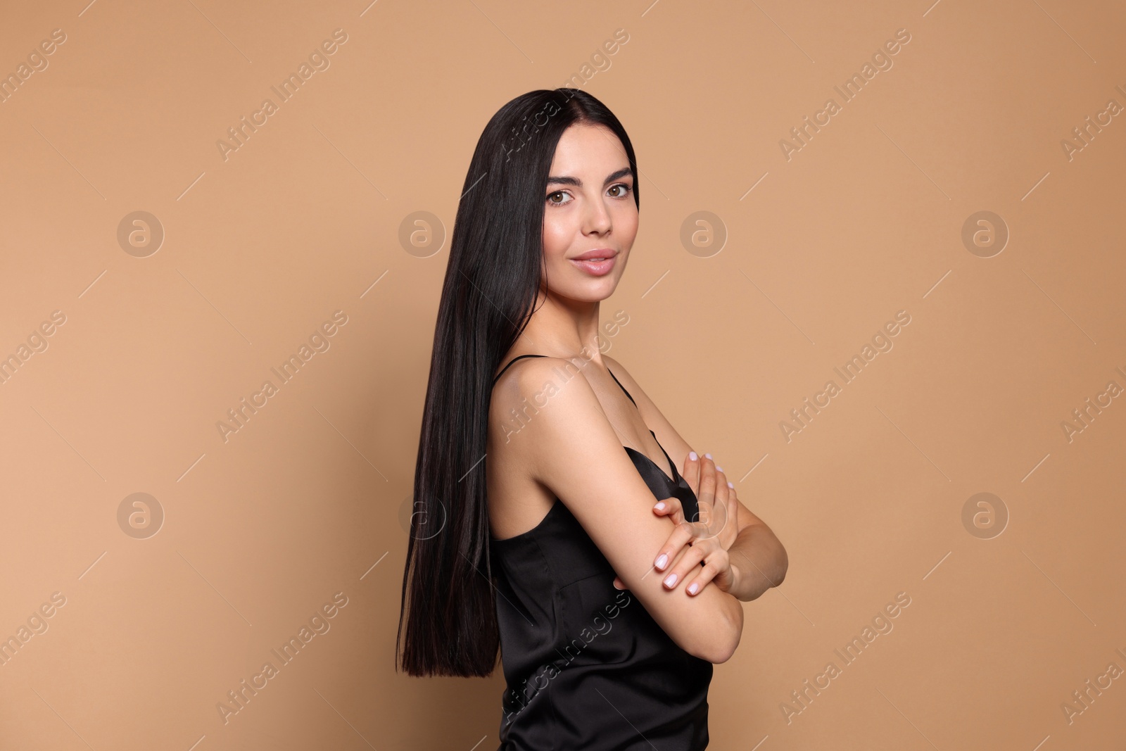 Photo of Portrait of beautiful young woman with healthy strong hair on beige background