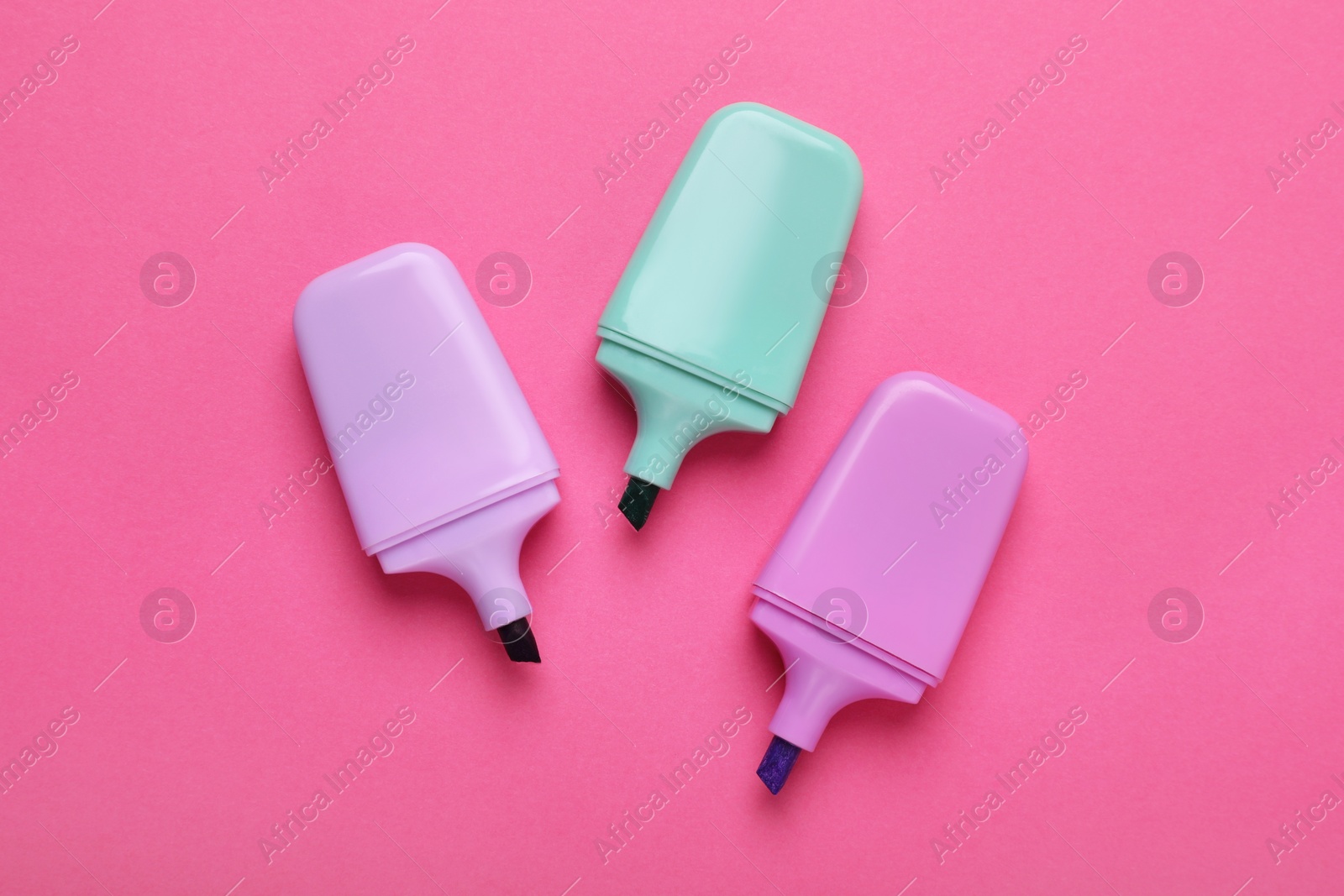 Photo of Colorful markers on pink background, flat lay