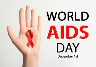 Image of World AIDS Day poster. Woman holding in hand red awareness ribbon near text on light background, closeup