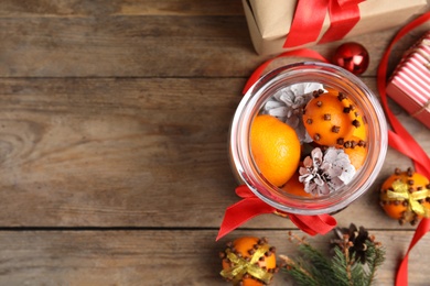 Flat lay composition with tangerine pomander balls on wooden table. Space for text