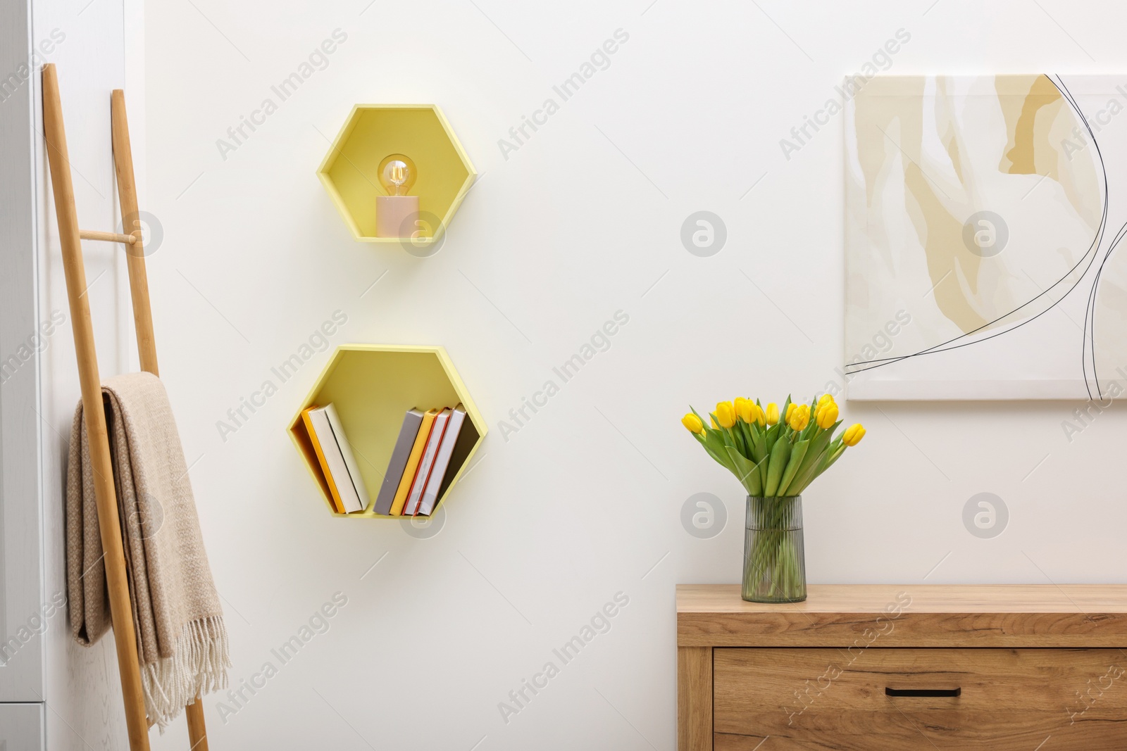 Photo of Spring interior. Stylish room with furniture and beautiful bouquet of yellow tulips