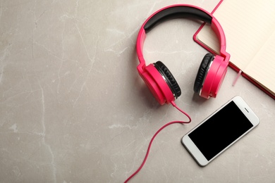 Photo of Flat lay composition with headphones, smartphone and notebook on table. Space for text