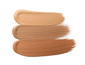 Photo of Samples of liquid skin foundation on white background, top view