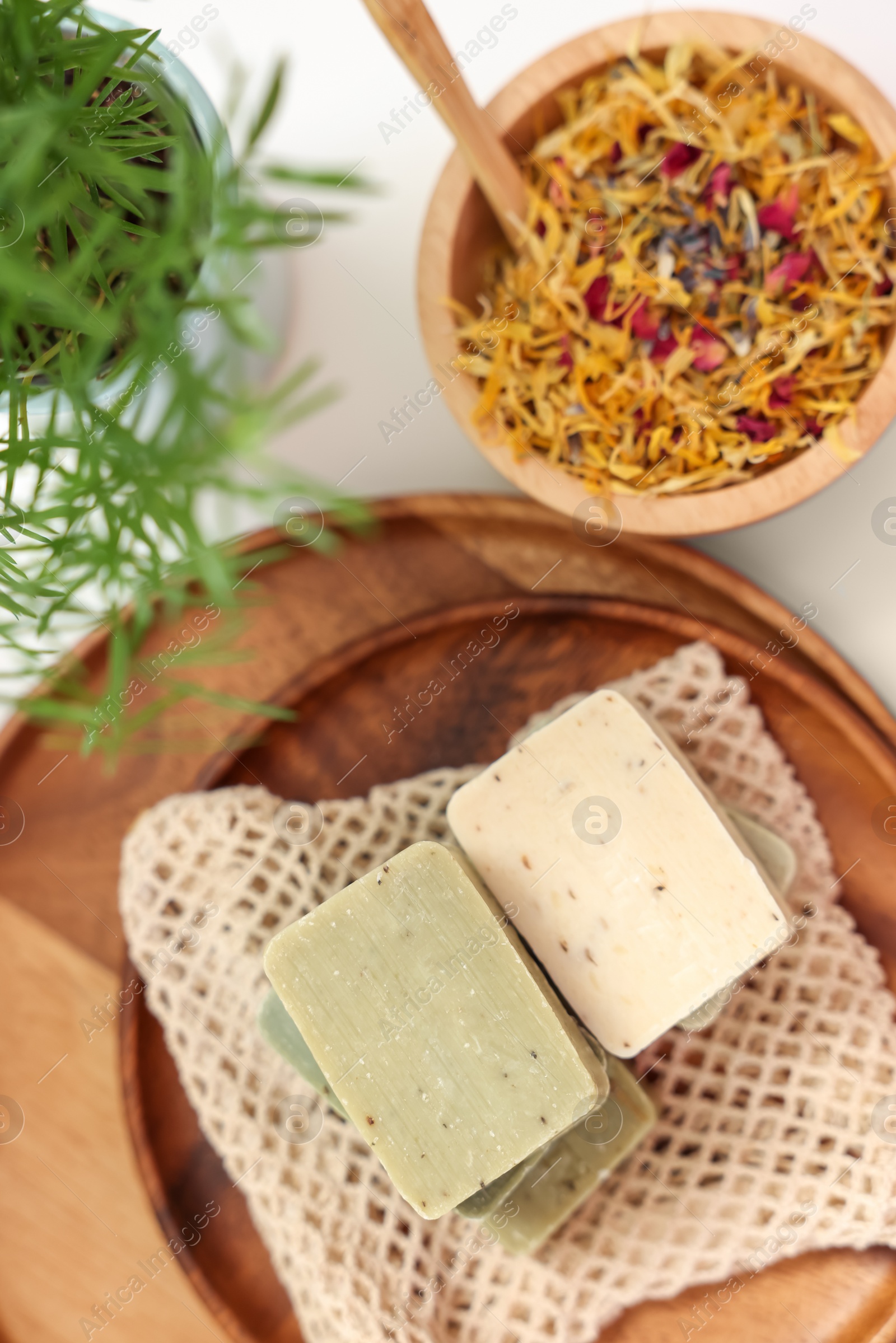 Photo of Soap bars and dry flowers on white table, flat lay. Spa time