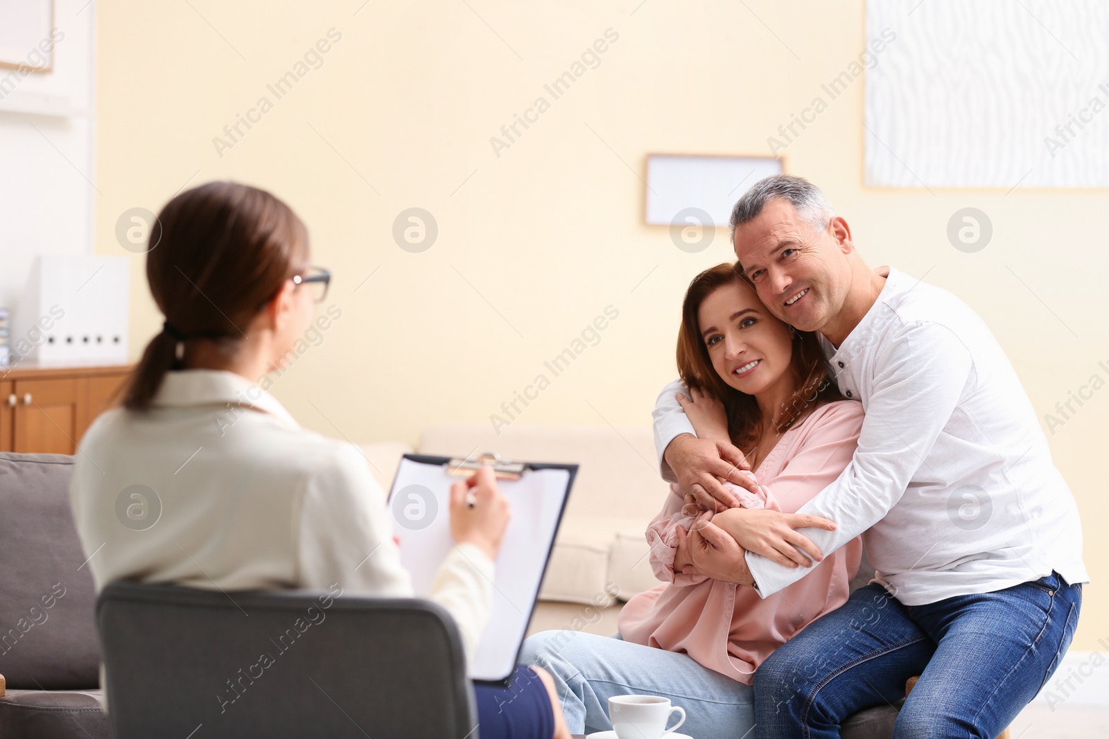 Photo of Psychotherapist and happy couple having meeting in office. Family counselling