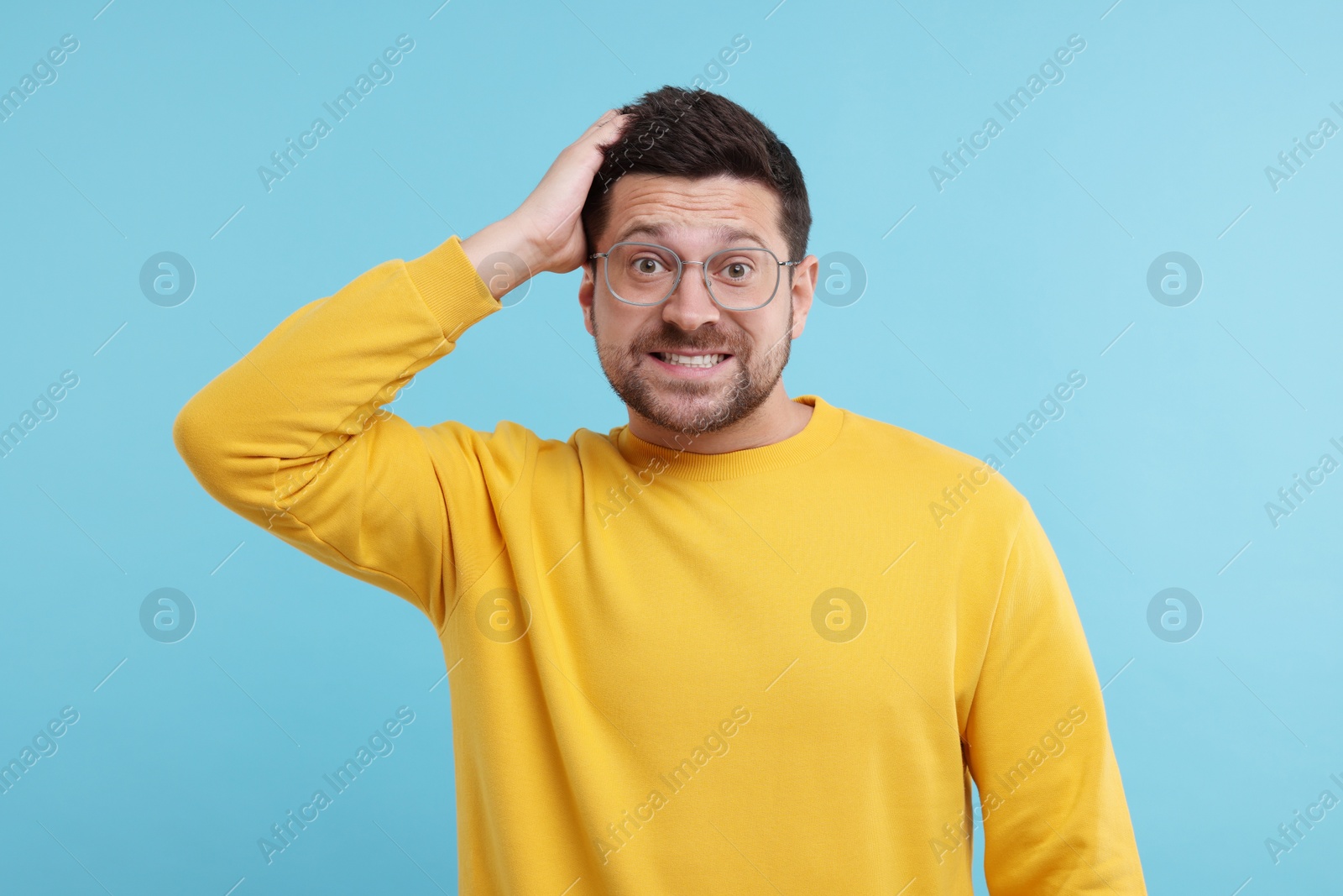 Photo of Portrait of embarrassed man on light blue background