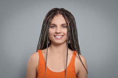 Photo of Beautiful woman with long african braids on grey background