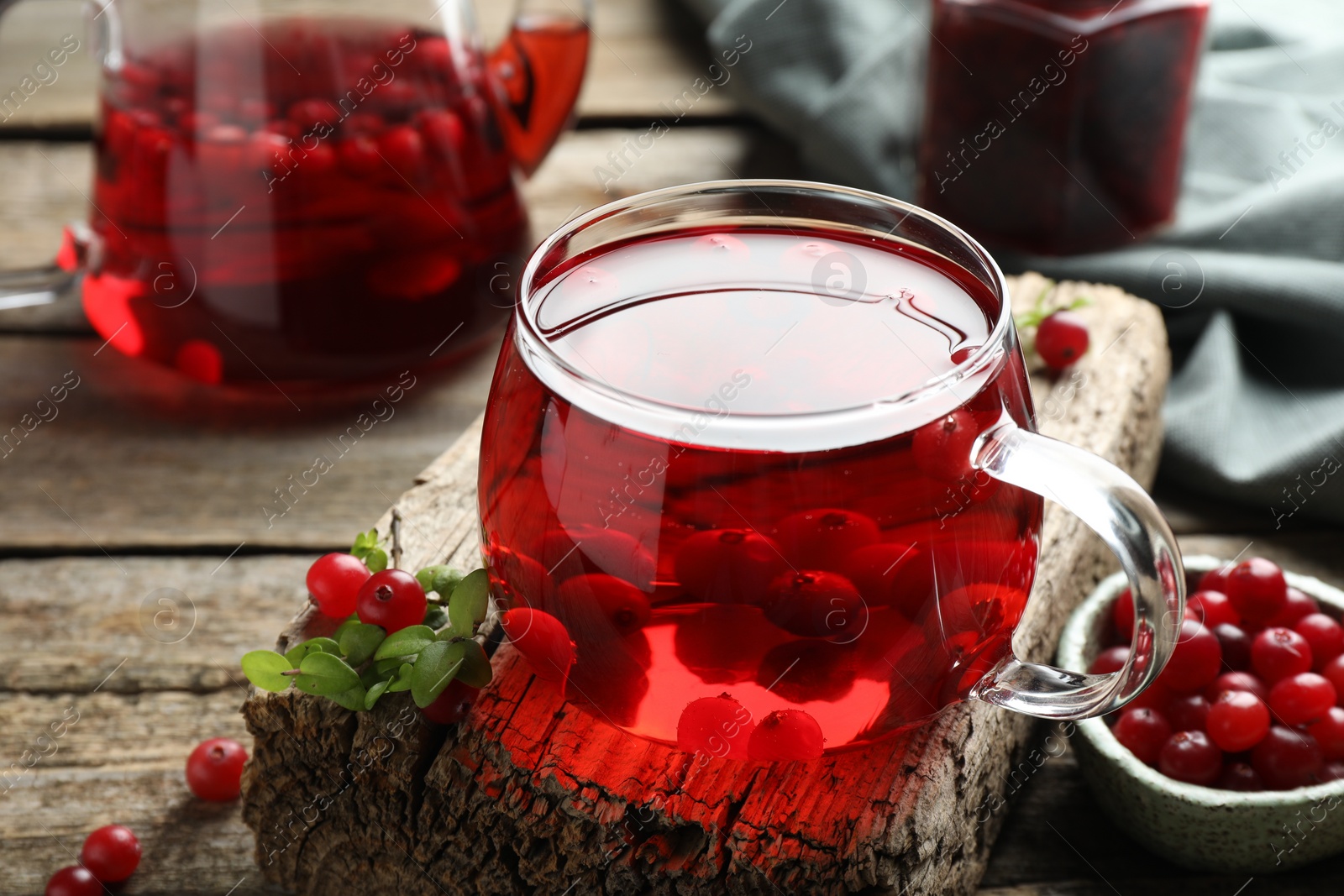 Photo of Delicious cranberry tea and berries on wooden table, closeup