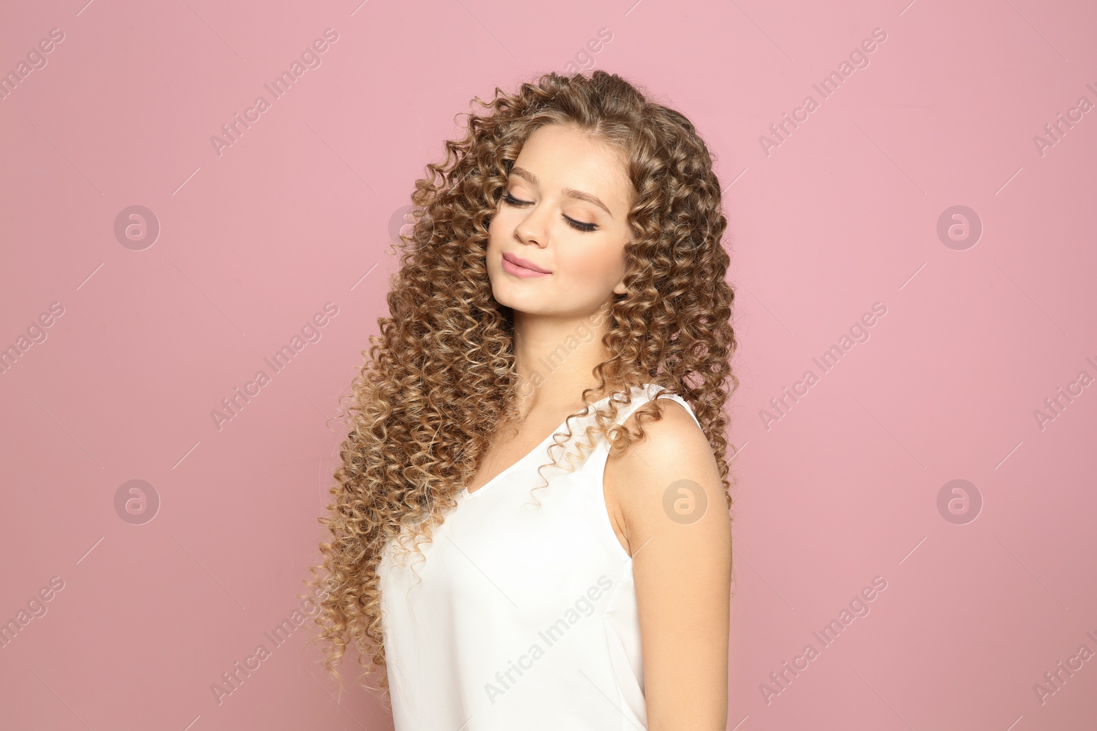 Photo of Portrait of beautiful young woman with shiny wavy hair on color background