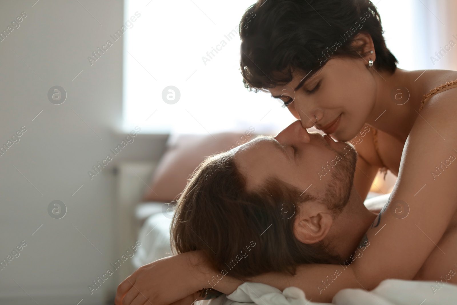 Photo of Lovely young couple being intimate on bed at home